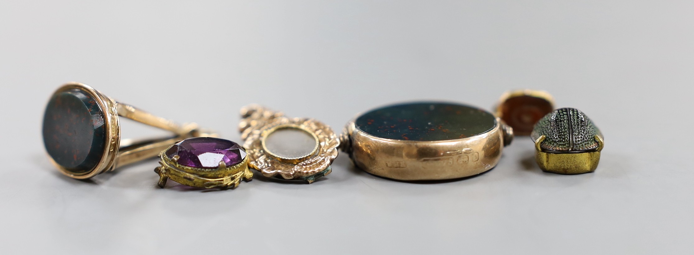 A late Victorian 9ct gold mounted carnelian and bloodstone set spinning fob seal, diameter 23mm, a later 9ct gold and bloodstone fob seal and four other items.